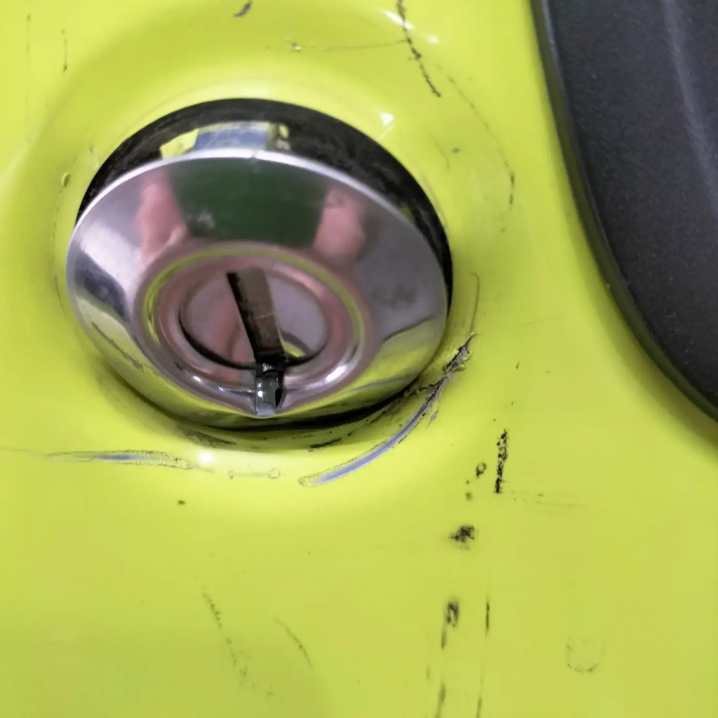 Damaged exterior lock on a Kinetic Yellow Suzuki Jimny
